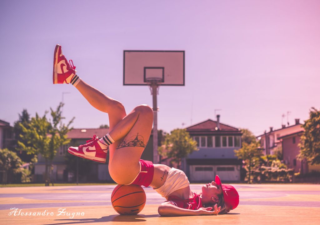 Modella posa su un campo da basket durante uno shooting fotografico